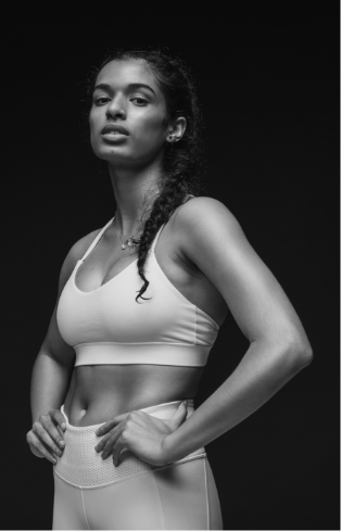 Gameplan member in athletic clothing and with hands on her hips.