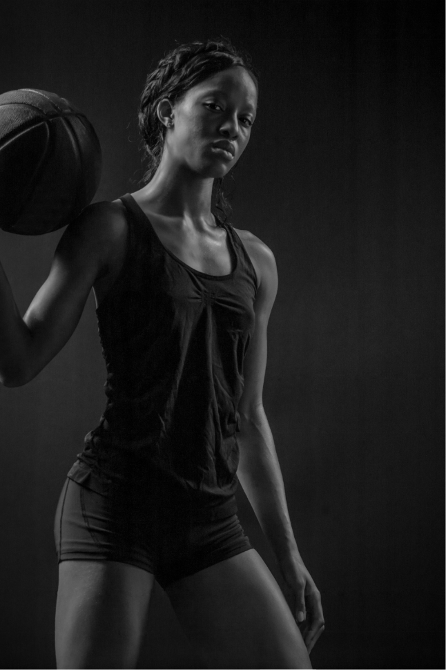 Gameplan member in athletic clothing and playing with a basketball.